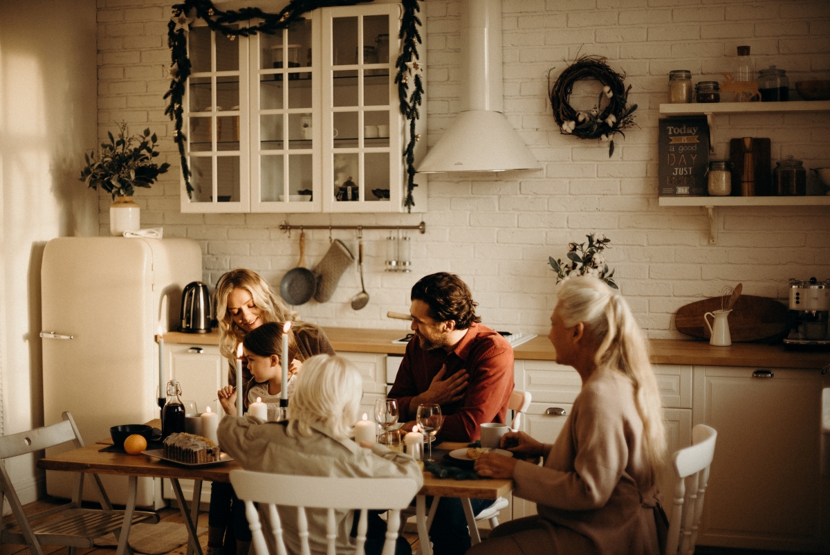 A warm and cozy family gathering in a beautifully decorated kitchen, enjoying a meal and discussing holiday planning.
