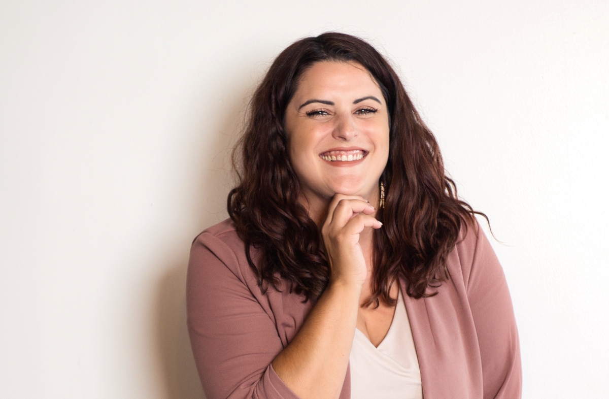 A confident woman smiling, symbolizing success and ambition.