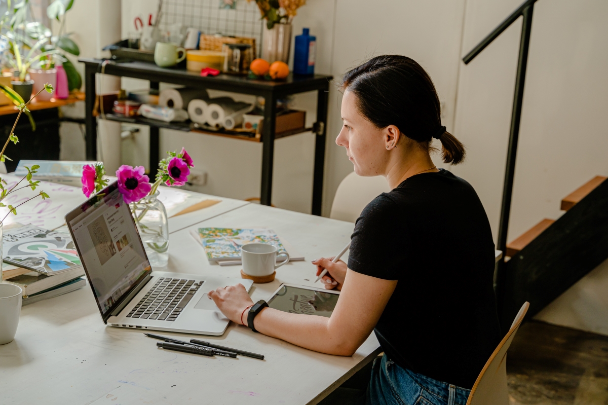 A confident woman sitting on a leather chair, representing a professional and strategic approach to working from home successfully.
