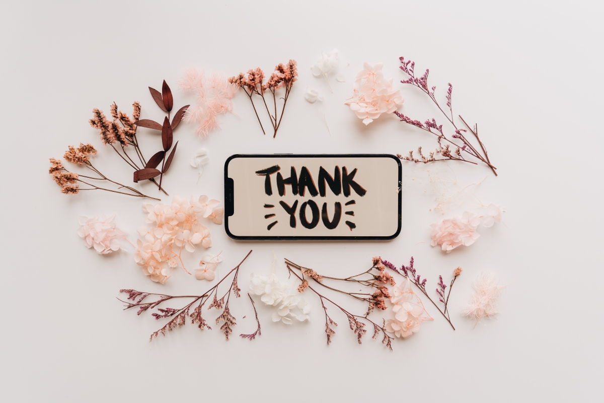 A phone displaying the words "Thank You" surrounded by delicate flowers, symbolizing gratitude and appreciation.