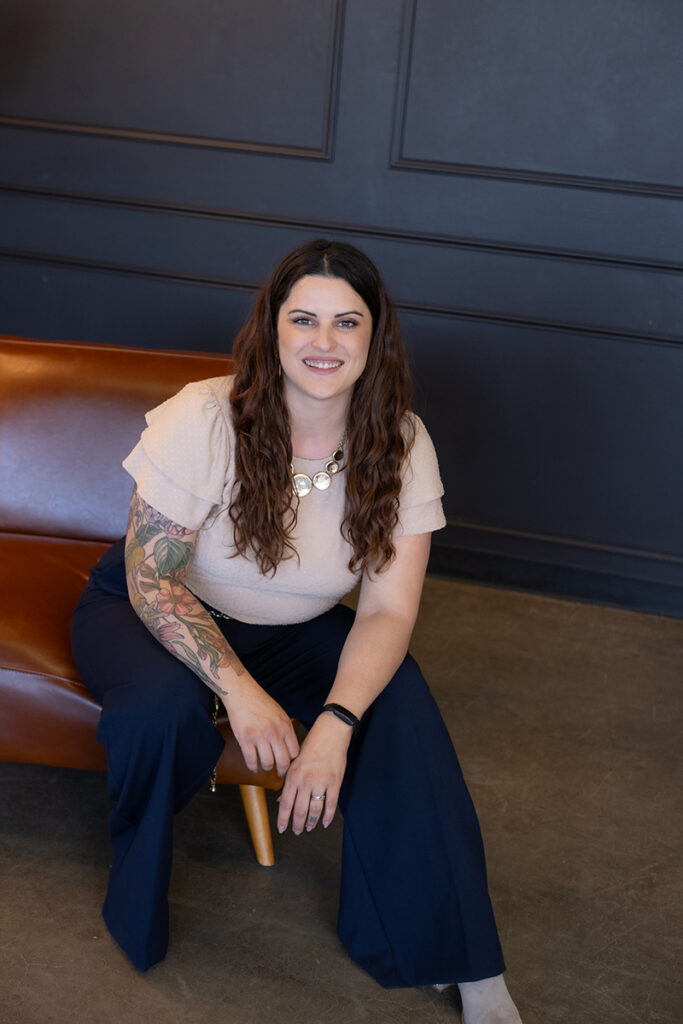 A professional from a virtual assistant agency seated confidently on a leather chair, smiling and ready to assist clients.