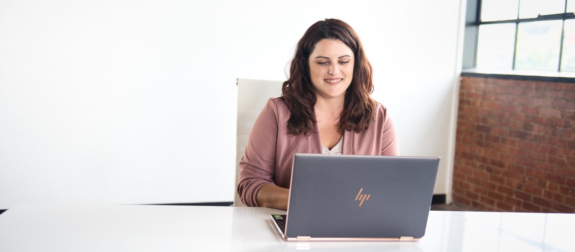 ceo-smiling-and-sitting-at-desk-on-laptop