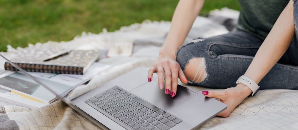 woman-on-computer-outside-in-the-grass