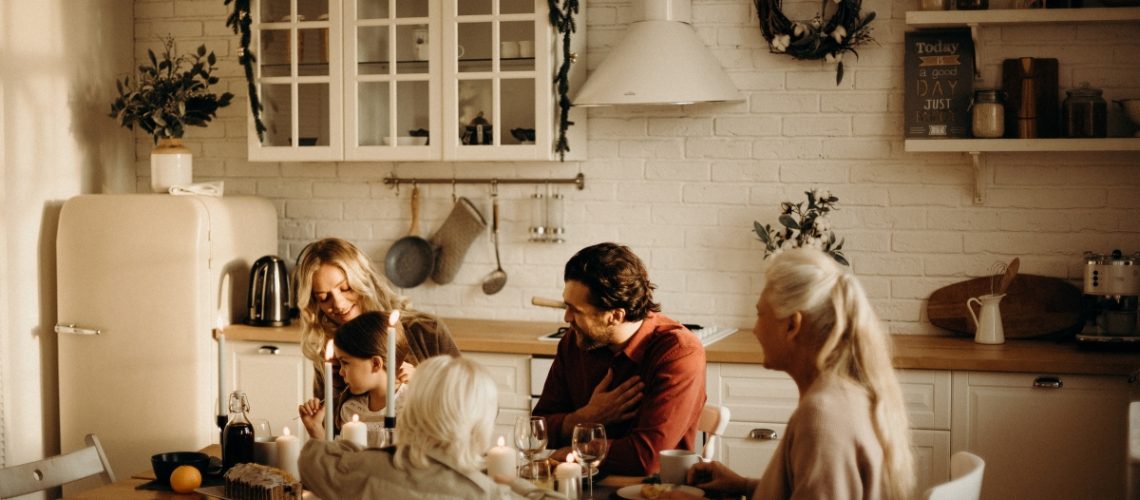 A warm and cozy family gathering in a beautifully decorated kitchen, enjoying a meal and discussing holiday planning.