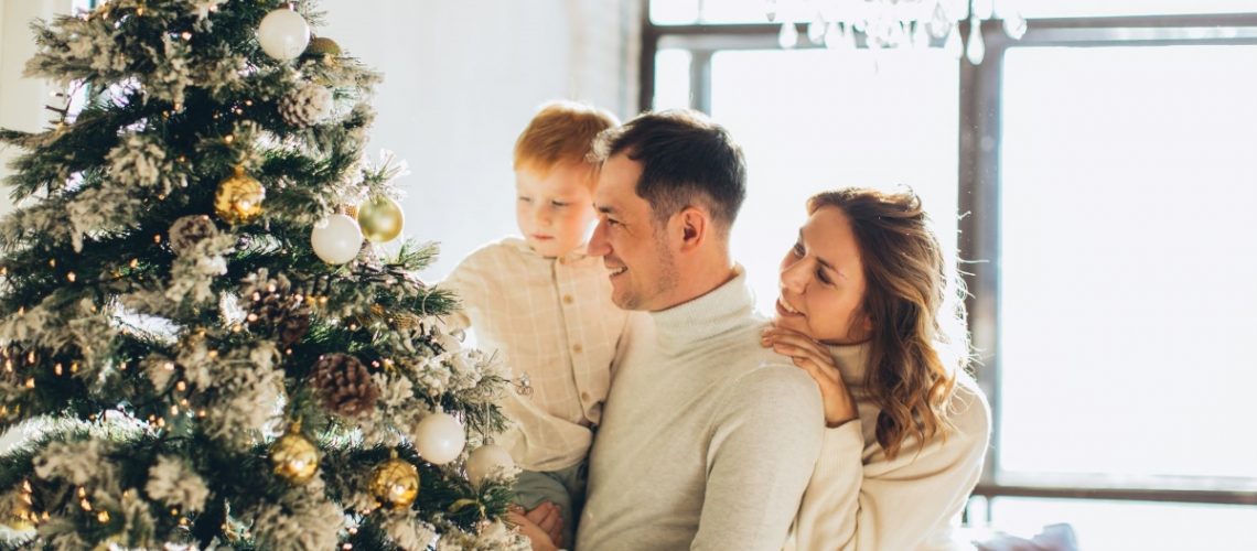 A happy family decorating their Christmas tree together, symbolizing warmth, love, and setting up for success during the holidays.
